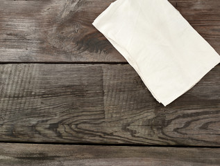 white kitchen textile towel folded on a gray wooden table from old boards, top view, empty space