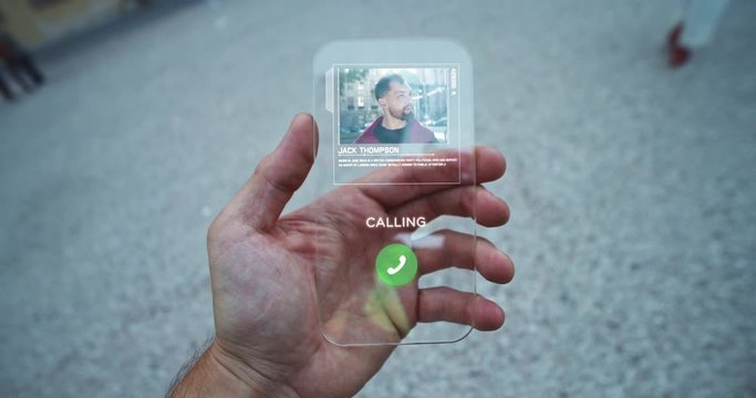 A Traveling Man recieving Income Call on his Transparent Phone. Latest Technology Concept of Digital Future. Futuristic Device shows social status of Caller. Smart Mobile Network of Internation World