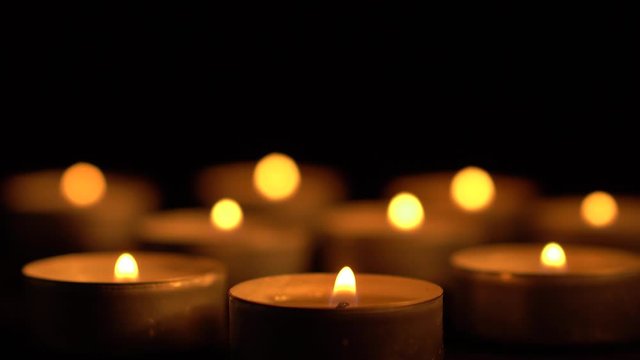 Slow motion white candles light up flames fire on isolated black background. Use in romantic dinner, warm and relax peace maditaion, use for spiritual religion church decotion and Halloween graveyard