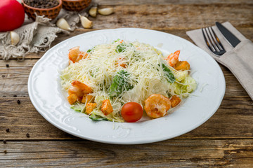salad caesar with shrimps on white plate