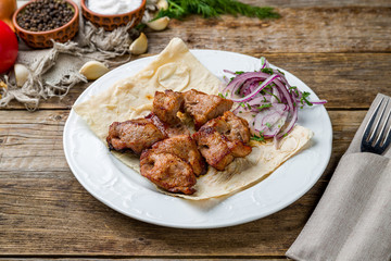 Kebab of pork on wooden table