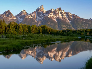 Fototapeta premium sunrise shot of grand teton and a stream schwabachers landing