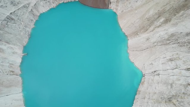 Abstract Aerial View on Aqua Blue Water Deep in Artificial Crater. Alta Mine, Montana USA
