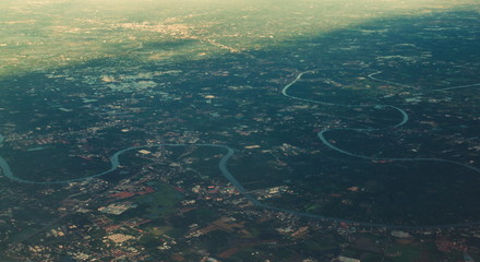Fototapeta na wymiar Aerial view of Chao Phraya River. Rural area and agricultural area at sunset. Houses in village and trees in forest in Bangkok City, Thailand