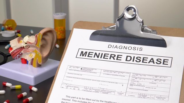 Meniere Disease patient diagnosis on a medic office with pills, stethoscope and anatomy models. Camera panning reveling the notebook with the medical record copy.