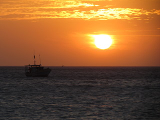 Fototapeta na wymiar Fishing boat starting work at sunset.