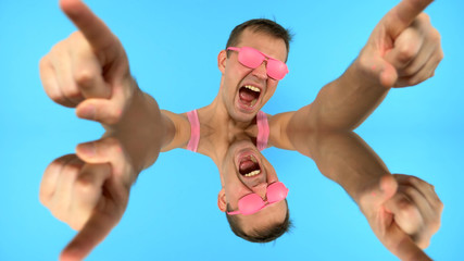 Funky stylish handsome guy in pink sunglasses.  man freak screaming .