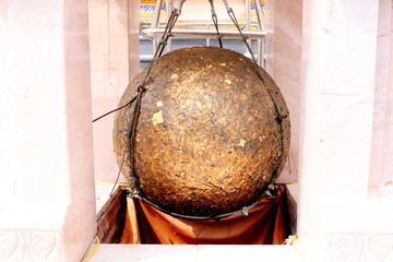 Luknimit is hanging in white cement frame and cover with gold leaves, Thailand. Luknimit is  round stones buried in the ground to mark the sacred limits of a temple.
