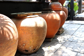 Row of earthen jars and rough gray floor, retro style jar in Thailand.