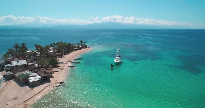 Aerial forward over small caribbean island, garifuna fishing village of Cayos Cochinos, Roatan