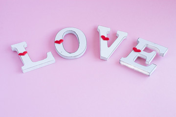 Word love written in wooden letters on a pink background. Valentine's Day celebration concept. Flat