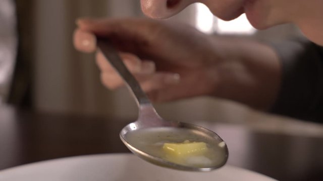woman eating soup at home close-up