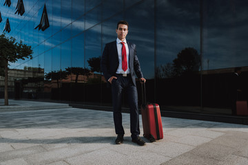 Businessman with suitcase in city stock photo