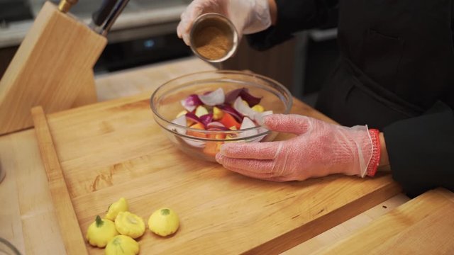 Taking cumin and seasoning the vegetables enough to make it tasty and ready for grilling.
