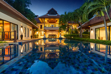 Obraz premium Thai Balinese luxury home with infinity swimming pool , night time