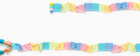 Knitted long scarf in pastel colors. Unicorn style. White background.
