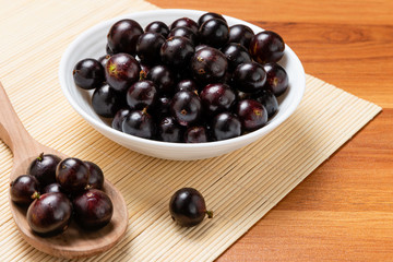 Jabuticaba in the wooden spoon and bowl. Jaboticaba or Jabuticaba is the native Brazilian grape tree. Species Plinia Cauliflora. Brazilian Berry.
