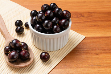 Jabuticaba in the wooden spoon and bowl. Jaboticaba or Jabuticaba is the native Brazilian grape tree. Species Plinia Cauliflora. Brazilian Berry.