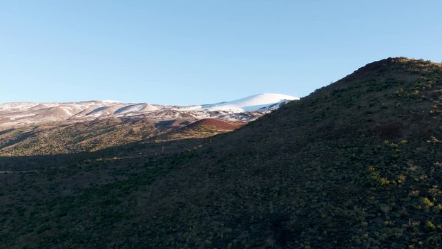 Mauna Kea Visitor Center Drone Reveal with Snow-topped peak in the background
