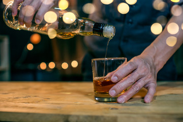 Barman pouring whiskey whiskey glass