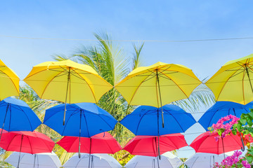 Street decorated with colorful umbrellas hanging on top side in the sky. Colorful umbrellas background.