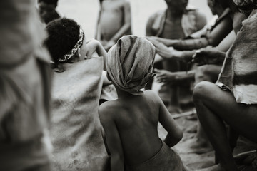 an African kid from behind in group of people black and white