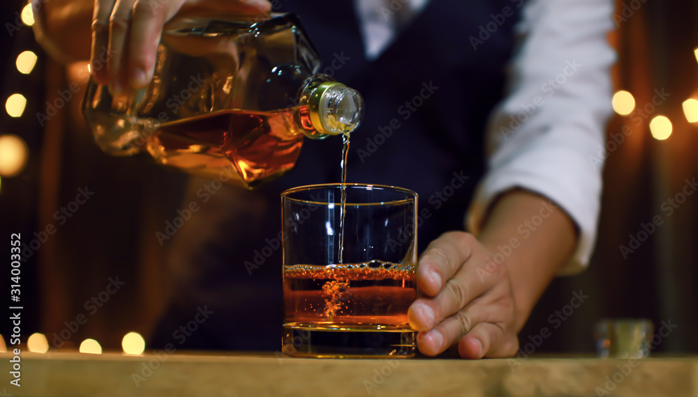 Wall mural bartender serve whiskey, on wood bar,