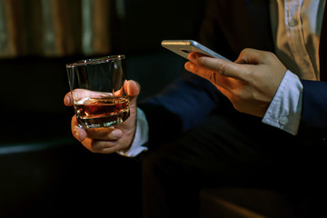 Closeup businessmen holding a glass of whiskey