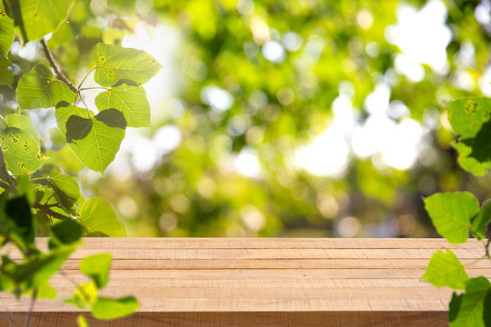 Empty wooden table with Defocus nature green bokeh, abstract nature background.