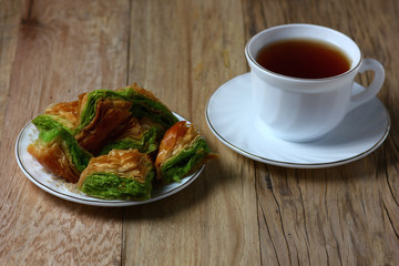 textured sweet puff pastry cakes on a wooden table with a white Cup