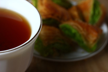 breakfast with sweet puff pastry cakes on a wooden table with a white Cup