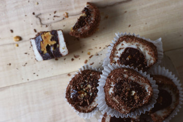 top view of a dessert sprinkled with chocolate chips and nuts lying on a wooden table