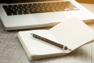 empty sketch book on top wooden table with computer notebook