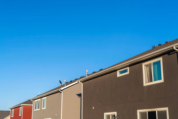 Houses with close up view of exterior walls windows and roofs against blue sky