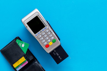 Pay by card. Plastic card inserted in terminal on blue background top-down copy space