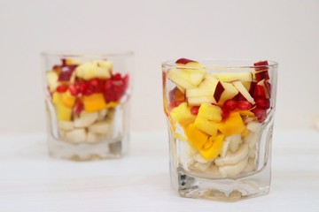 Mango & vanilla ice cream served with Mixed chopped fruits like Bananas, Mangoes, pomegranates, apples garnished with chocolate syrup in a glass. known as Gad bad ice cream in India