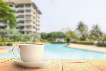 coffee on wooden table at swimming pool at hotel