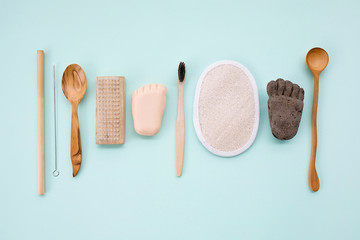 Natural bathroom accessories: luffa washcloth, make up remover in a glass container, wooden comb, organic bath salt, bamboo toothbrush, volcanic pumice and coconut solid soap.