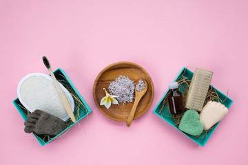 Natural bathroom accessories in two boxes: luffa washcloth, make up remover in a glass container, wooden comb, organic bath salt, bamboo toothbrush, volcanic pumice and coconut solid soap.