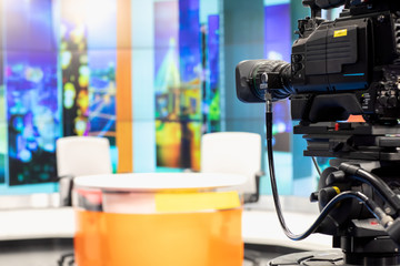 Camera in studio are broadcasting journalists reading news.Blur background have table for reporter. - obrazy, fototapety, plakaty