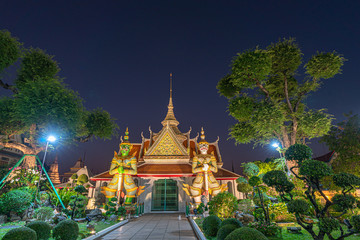 Large illuminated temple Wat Arun after sunset seen accross river Chao Phraya Bangkok, Thailand.golden Buddha in side temple Wat Arun the biggest and tallest pagoda in the world