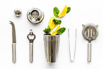 Bartender work desk with equipment and cocktail ingredietns Shaker, lime, ice on white background...