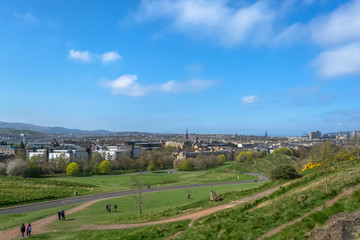 Fototapeta na wymiar General aerial view from the Holyrood Park to the Edinburgh downtown city, monument buildings, mountains and parks on background
