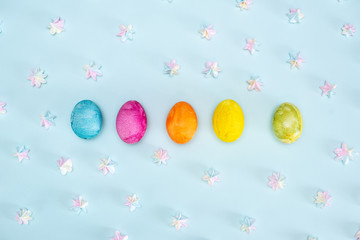 Easter background with blue and white eggs in nest and yellow tulips. Top view with copy space