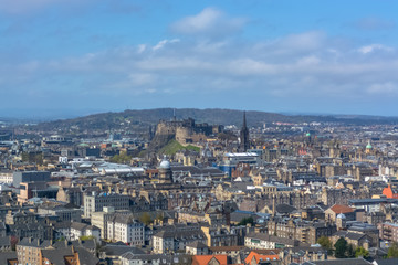 General aerial view from the Holyrood Park to the Edinburgh downtown city, monument buildings, mountains and parks on background