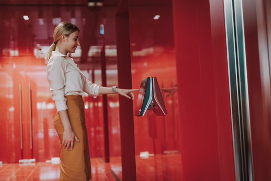 Smiling elegant lady entering access code in business center