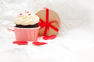 Valentine's day. Festive cake with cream and sprinkled with small hearts. The sweetness on birthday. Valentine's day cake.