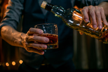 Barman pouring whiskey whiskey glass.