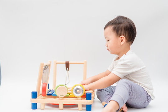 Little baby drummer boy playing percussion and hitting the drum set at home.Asian boy playing and singing happy moment in music lesson time.Child development and Executive function in child concept.