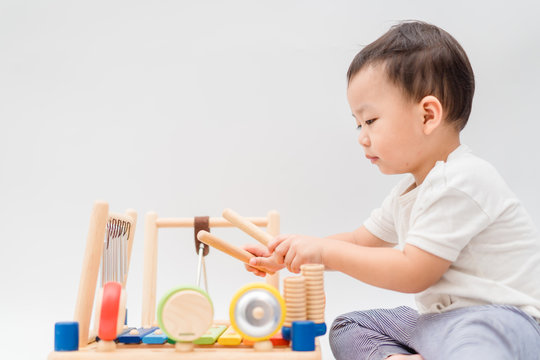 Little baby drummer boy playing percussion and hitting the drum set at home.Asian boy playing and singing happy moment in music lesson time.Child development and Executive function in child concept.
